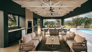 A spacious outdoor living area with a pool, seating, and a view of the landscape. - Summerplace Game Reserve (Vaalwater)