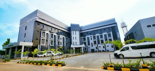 A modern building with a large entrance, multiple floors, and a prominent tower. - Cathelea Convention and Suites (Benin City)