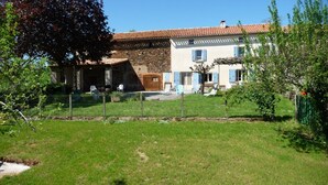 Un bâtiment à deux étages, doté d’une façade en pierre et d’un toit recouvert de tuiles.
