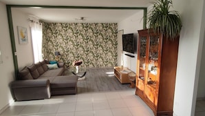 Un salon comprenant un canapé, une table basse, un meuble et un téléviseur.
