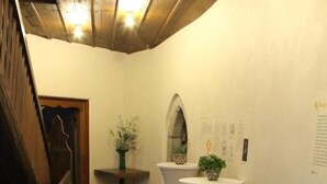 A wooden-floored corridor with white round tables and a staircase. - HotelBurg Falkenberg (Falkenberg)