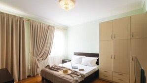 Una habitación de hotel con cama, armario y escritorio con silla.