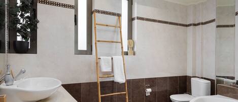 A bathroom with a wooden floor, a white sink, a toilet, and a bathtub.