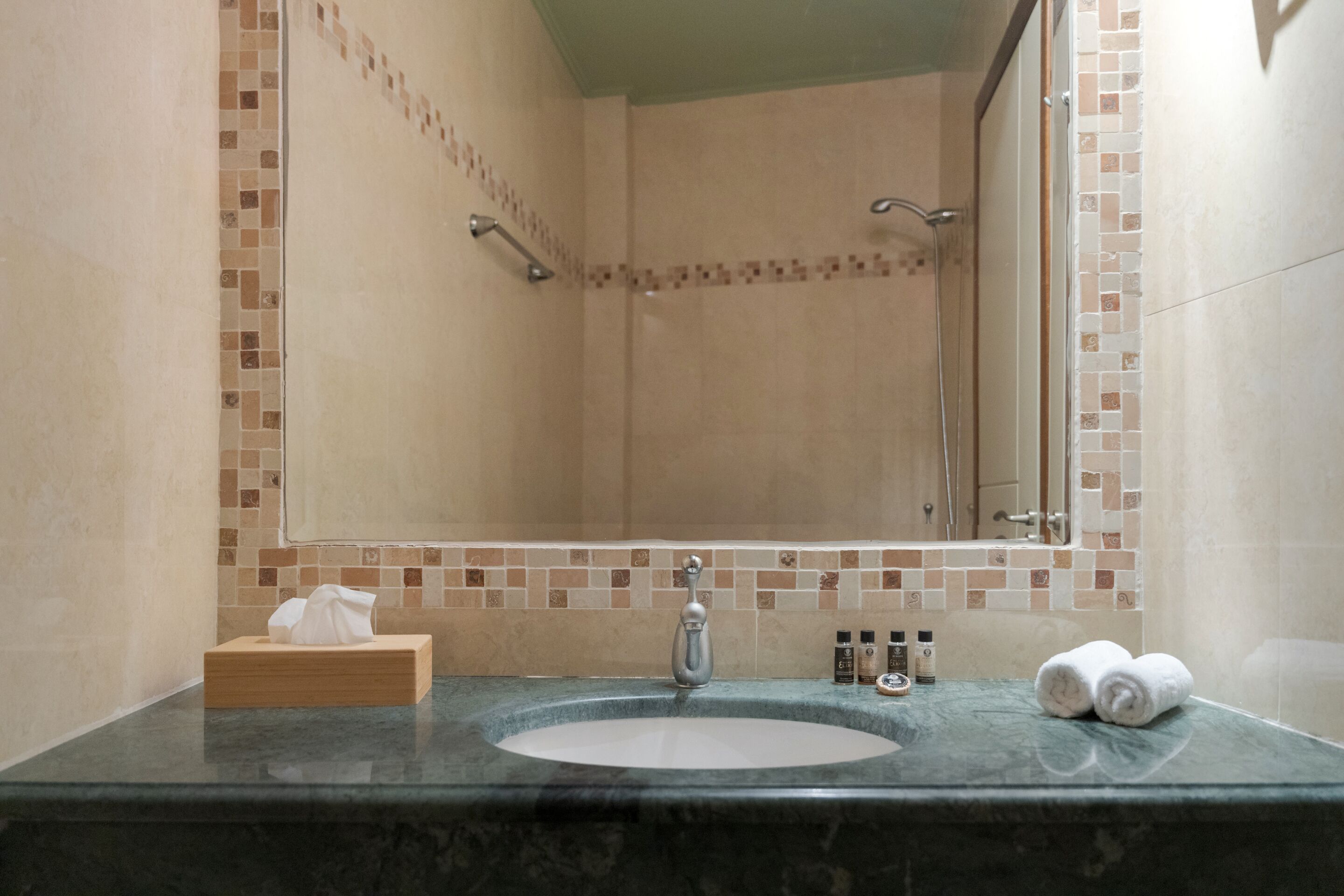 Ein Badezimmer mit Waschbecken, Spiegel und Dusche.