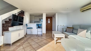 Eine moderne Wohnung mit Wohnbereich, Küche und einer Treppe.