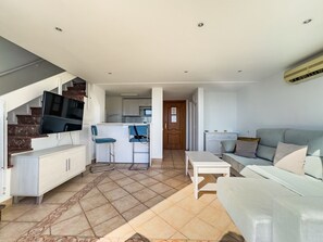 A modern apartment with a living area, kitchen, and a staircase. - Skol 925. Duplex Apartment With Amazing Views to the Marbella Port (Marbella)