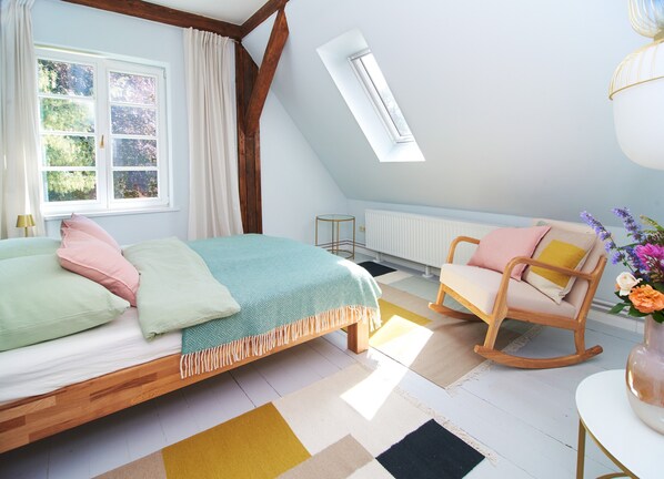 A bedroom with a bed, a rocking chair, a window, and a radiator. - Guest House 'Charming Studio Apartment' with Shared Terrace and Wi-Fi (Meezen)