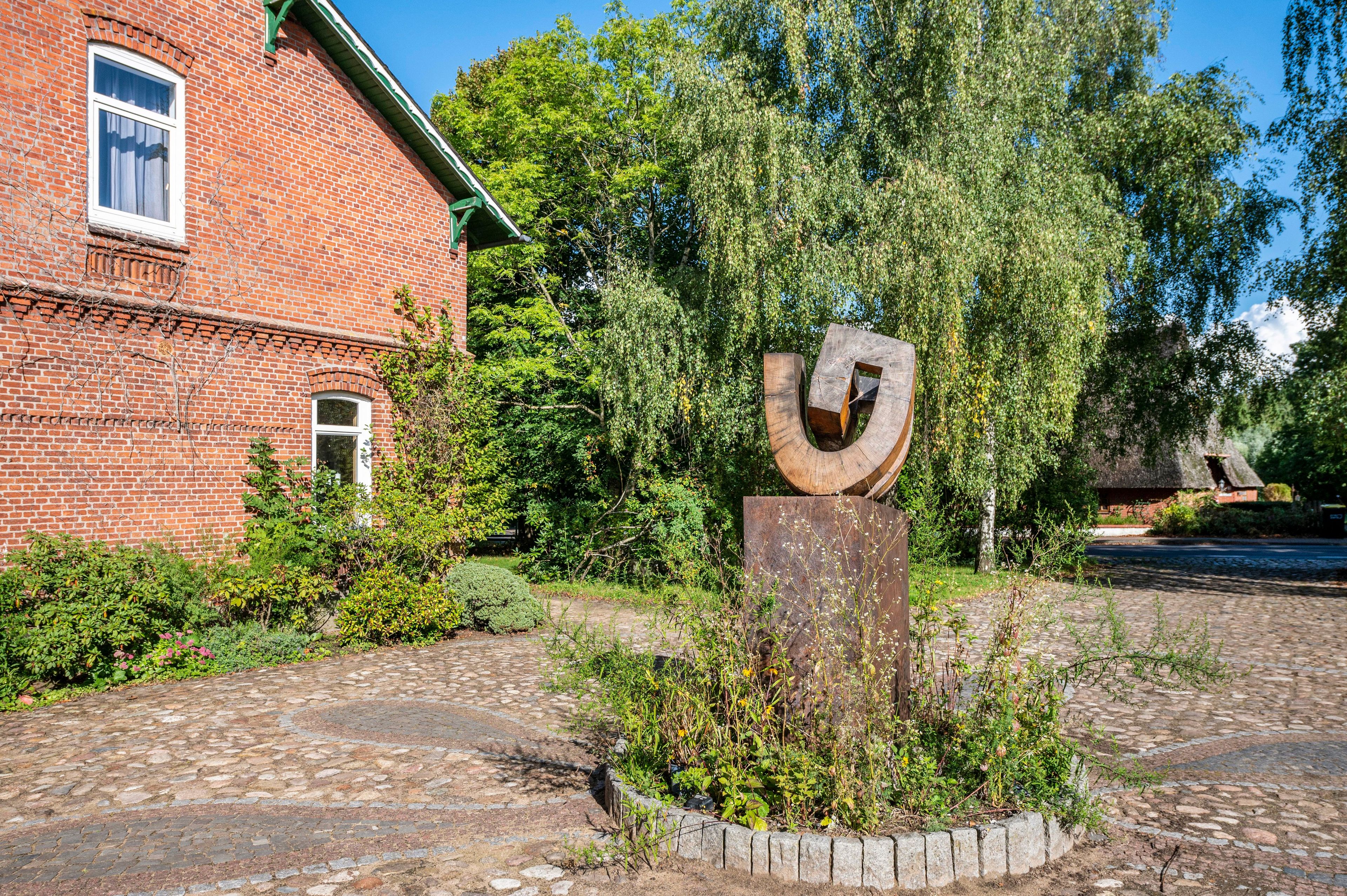 A brick building with a metal sculpture in front.