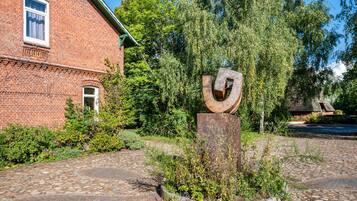 A brick building with a metal sculpture in front.