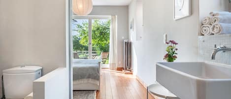 A modern bathroom with a bathtub, toilet, and shower area.