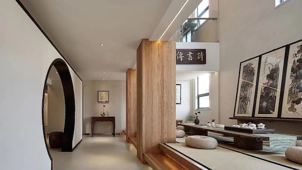 A modern interior with a wooden column, tatami mats, and traditional artwork. - Huangshan Old Street Garden Boutique  (Huangshan)