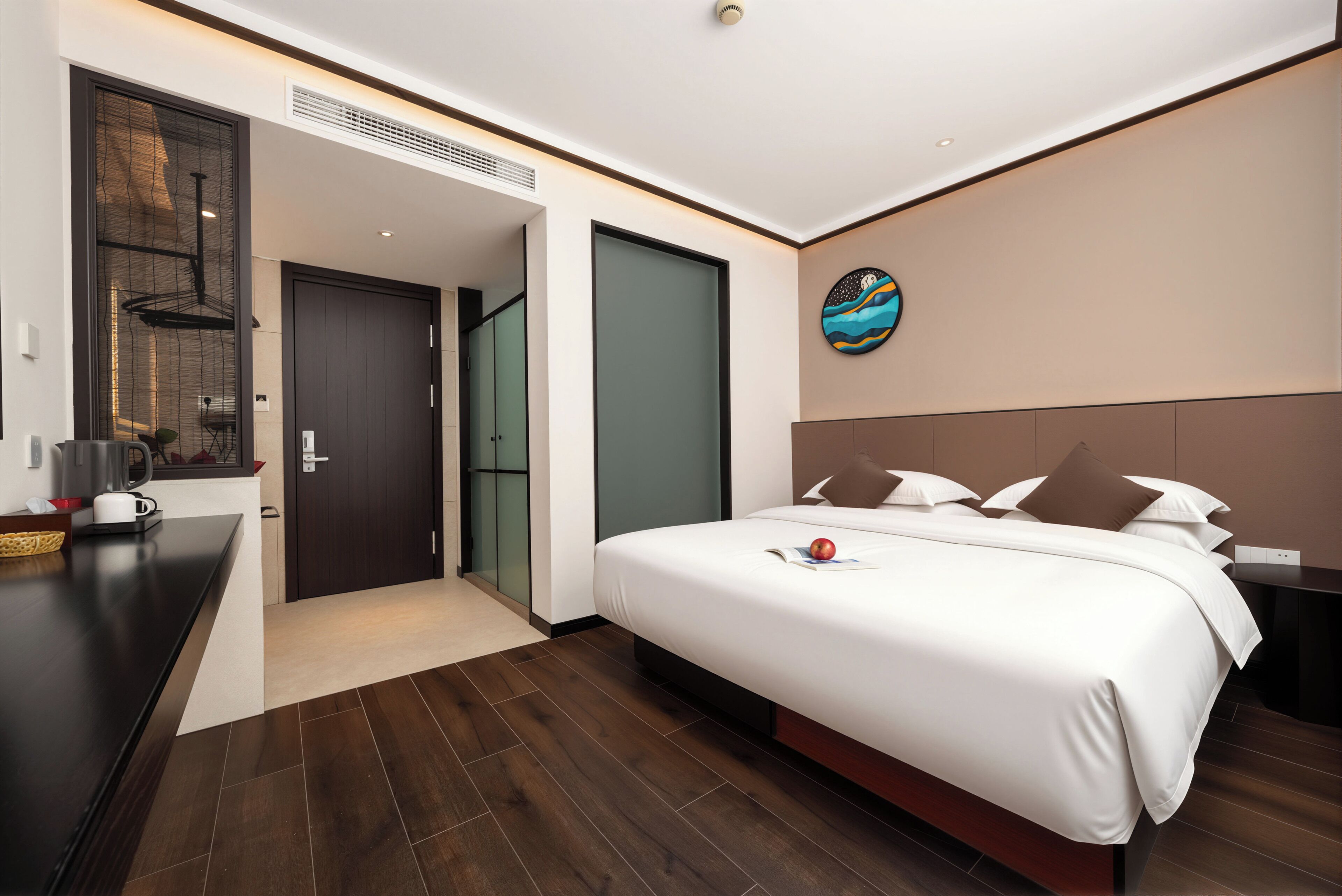 Ein modernes Hotelzimmer mit einem großen Bett, einem Schreibtisch und einem Wandbild.