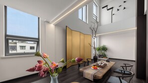 A modern interior with a dining area, a large window, and a view of the sky. - Huangshan Old Street Garden Boutique  (Huangshan)