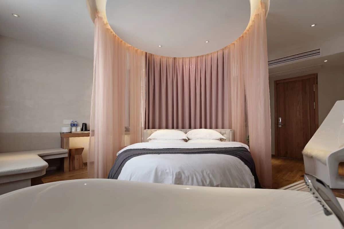 Um quarto moderno com uma cama grande, um espaço de estar e uma cadeira de massagem.