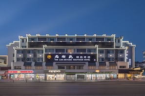 A multi-story hotel with a prominent sign for 'The Lao Jieyuan Boutique Hotel' and an 'Oppo' store on the ground floor. - Huangshan Old Street Garden Boutique  (Huangshan)