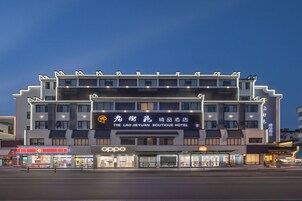 A multi-story hotel with a prominent sign for 'The Lao Jieyuan Boutique Hotel' and an 'Oppo' store on the ground floor.