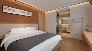 A modern hotel room with a large bed, a bedside table, a mirror, and a bathroom visible through an open door. - Huangshan Old Street Garden Boutique  (Huangshan)