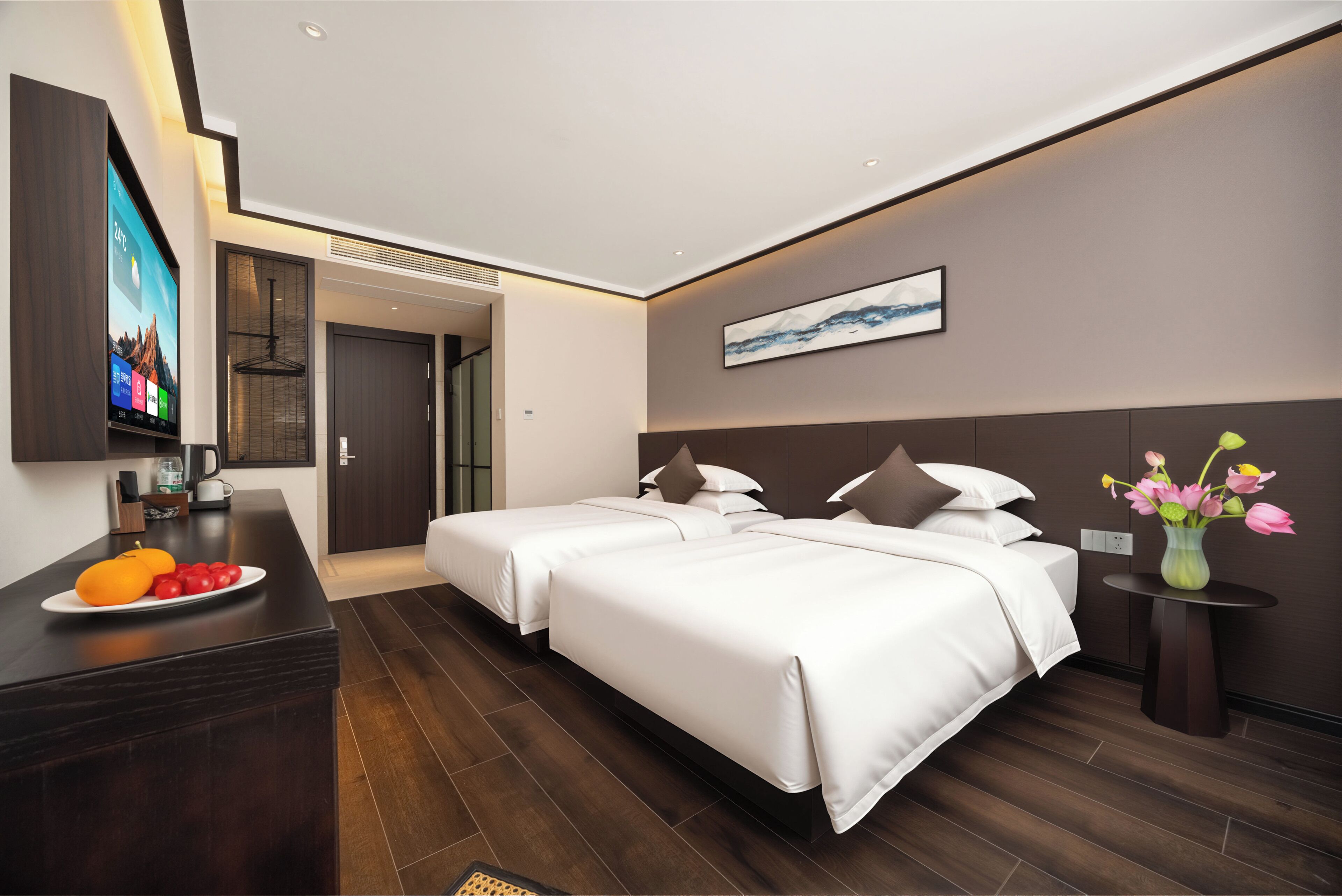 Une chambre d’hôtel moderne équipée d’un lit, de tables de chevet, d’un téléviseur et d’une assiette de fruits.