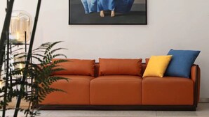 A modern living room with a sofa, a painting, and a potted plant. - Huangshan Old Street Garden Boutique  (Huangshan)