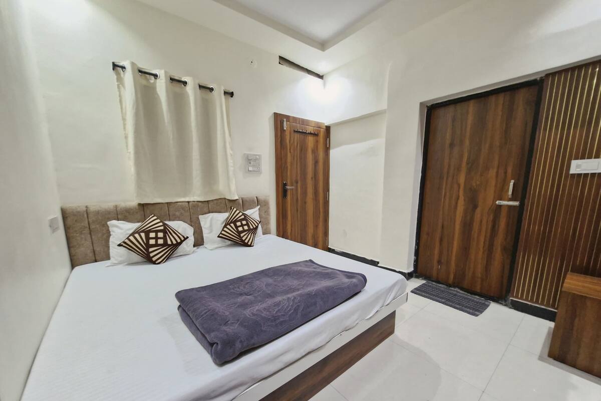 Un dormitorio con cama, armario de madera y una puerta.