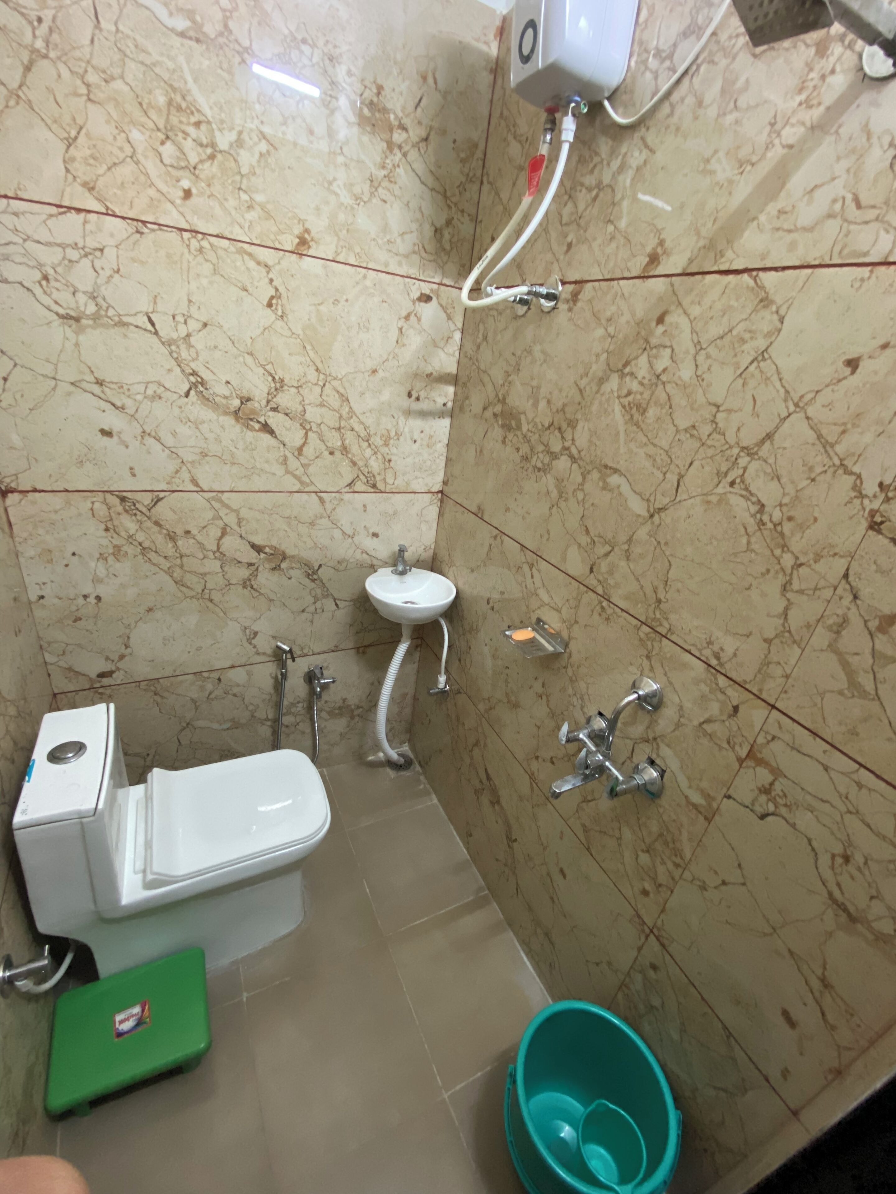 A compact bathroom with a toilet, sink, and shower.