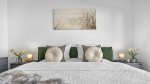 A modern bedroom with a large bed, green headboard, decorative pillows, bedside lamps, and a wall-mounted artwork. - Ella - Terrace, 2 parking spaces, washing machine, fireplace, ground floor (Olpenitz)