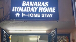 En hotellentrén med en skylt som visar texten: "BANARAS HOLIDAY HOME – boende".
