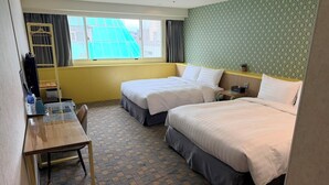 A hotel room with two beds, a desk, a chair, a small table, a window with curtains, and a patterned wall. - Ximenhotel Xining (Taipei)