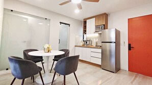 A modern kitchen with a stainless steel refrigerator, wooden cabinets, and a microwave. - Perfect for Digital Nomads | Studio in Condesa (Mexico City)