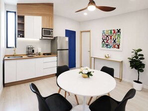 Eine moderne Küche mit weißen Schränken, einem Edelstahl-Kühlschrank und einer blauen Tür.