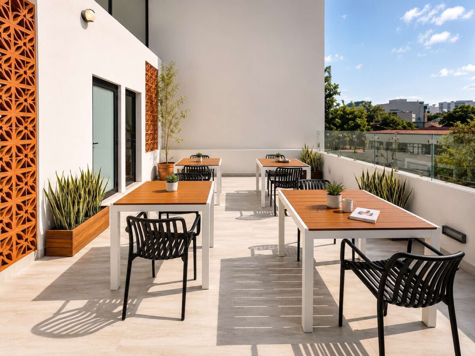 A rooftop terrace with outdoor seating, potted plants, and a view of the cityscape.