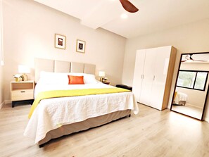 Quarto moderno com cama grande, armário e ventilador de teto.