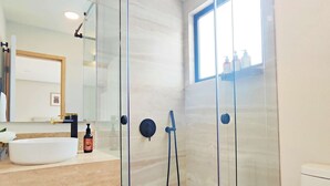 A modern bathroom with a glass-enclosed shower, a white sink, and a toilet. - Modern Condesa 1BR | King & Sofa Bed | Brand New (Mexico City)
