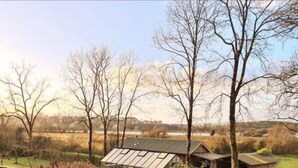 A garden with raised beds, a greenhouse, and a small wooden structure. - Waterside Cabin | Cavan Lakes | Hot Tub (CN)