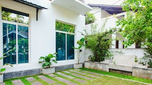 Une maison moderne avec une pelouse bien entretenue et une terrasse en bois.