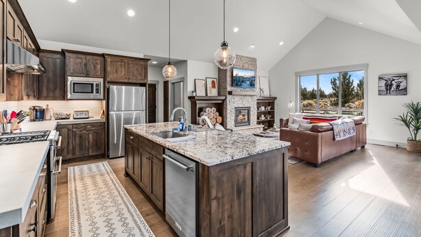 A modern kitchen with dark wood cabinets, stainless steel appliances, and a large island. - Brasada Ranch Elegance | Hot Tub| Bocce| Ping Pong (Powell Butte)