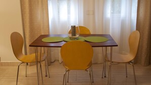 A dining table with a pitcher, two green placemats, and four yellow chairs. - Central location, parking, next to the train (Cordoba)