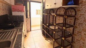 A kitchen with a stove, sink, and a wooden shelf unit. - Beach 2 minutes away - Quiet and ideal for families (M'diq)
