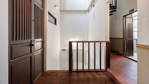 Un pasillo estrecho con puertas de madera y un portón de metal.