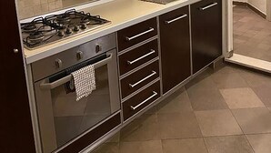 A kitchen with a gas stove, a sink, and cabinets. - 3 House by Ghor (Rome)