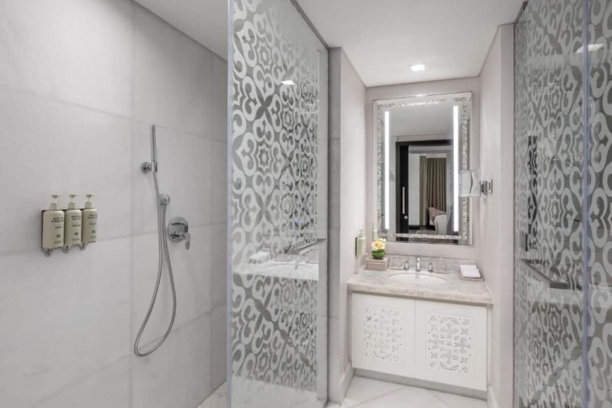 A modern bathroom with a shower, vanity, and a large mirror.