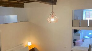 Ein Schlafzimmer mit Bett, Nachttischlampe und Pendelleuchte.