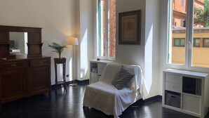 A room with a bed, a dresser, a lamp, and a window with a view of buildings. - Domus Parioli by Ghor (Rome)