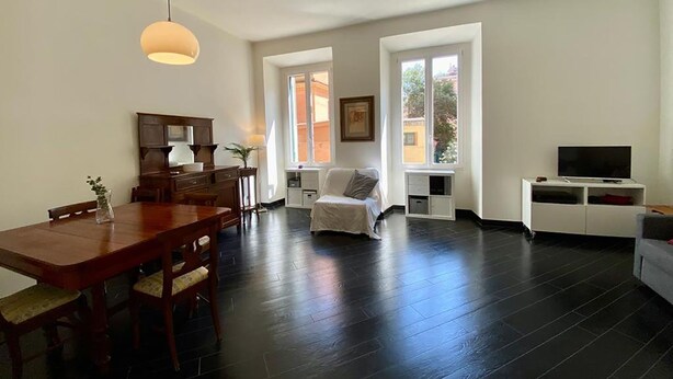 A modern living room with a dining area, large windows, and a flat-screen TV. - Domus Parioli by Ghor (Rome)