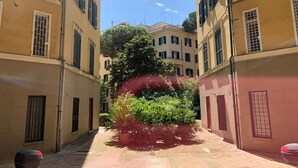 A narrow alleyway with buildings on either side, featuring balconies and windows with shutters. - Domus Parioli by Ghor (Rome)