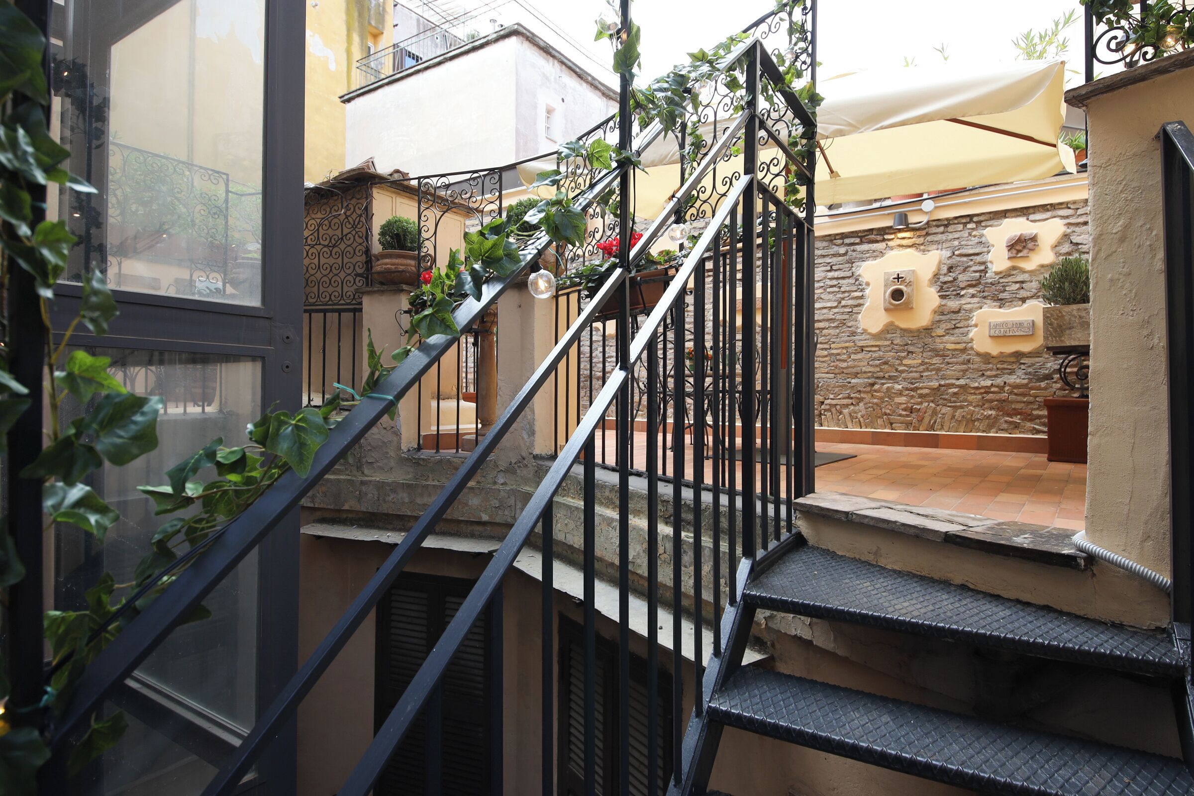 A narrow staircase with metal railings leading to a balcony.
