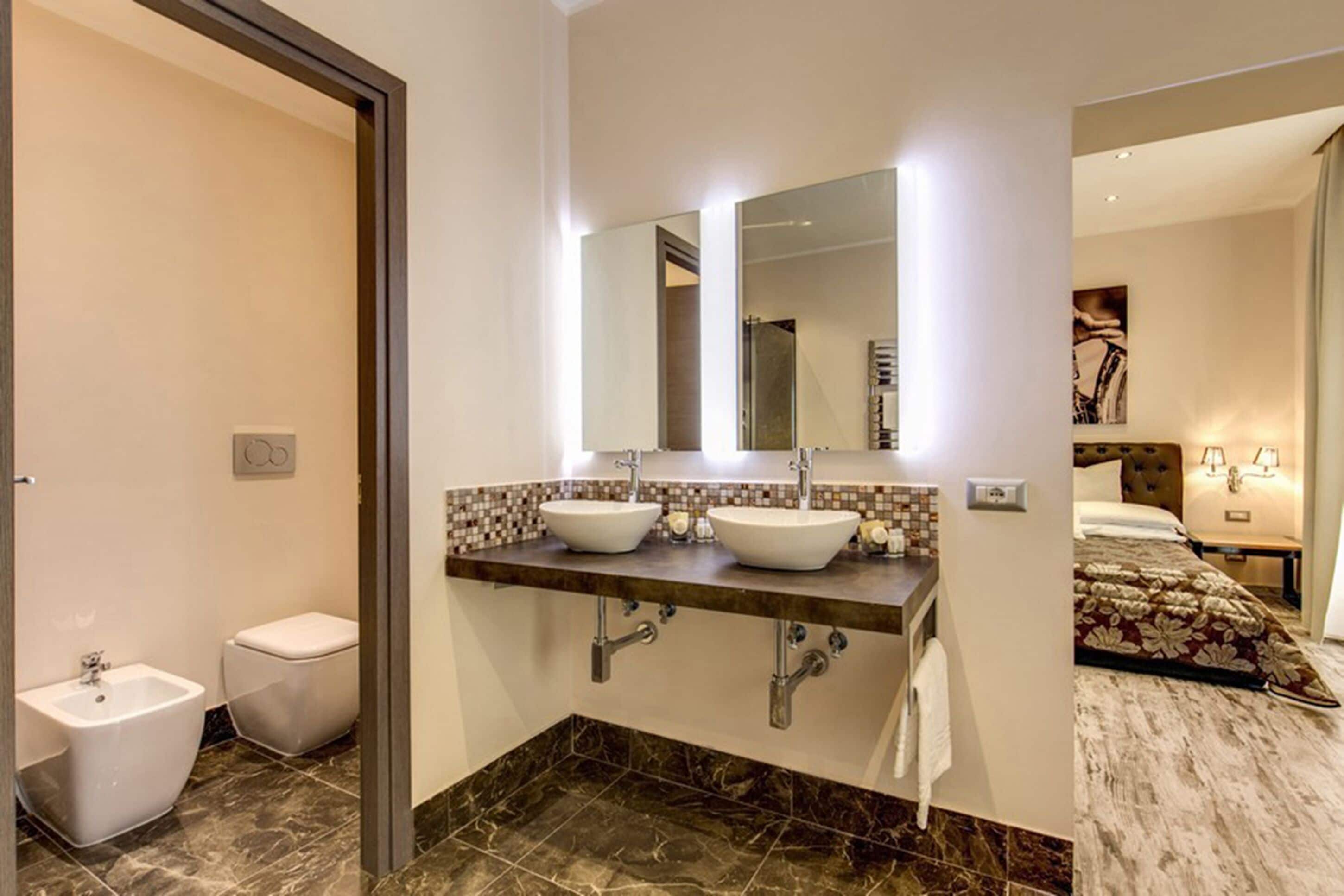 Un baño moderno con dos lavamanos, un inodoro y una ducha.