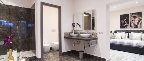 A modern bathroom with a large mirror, a bathtub, and a toilet.