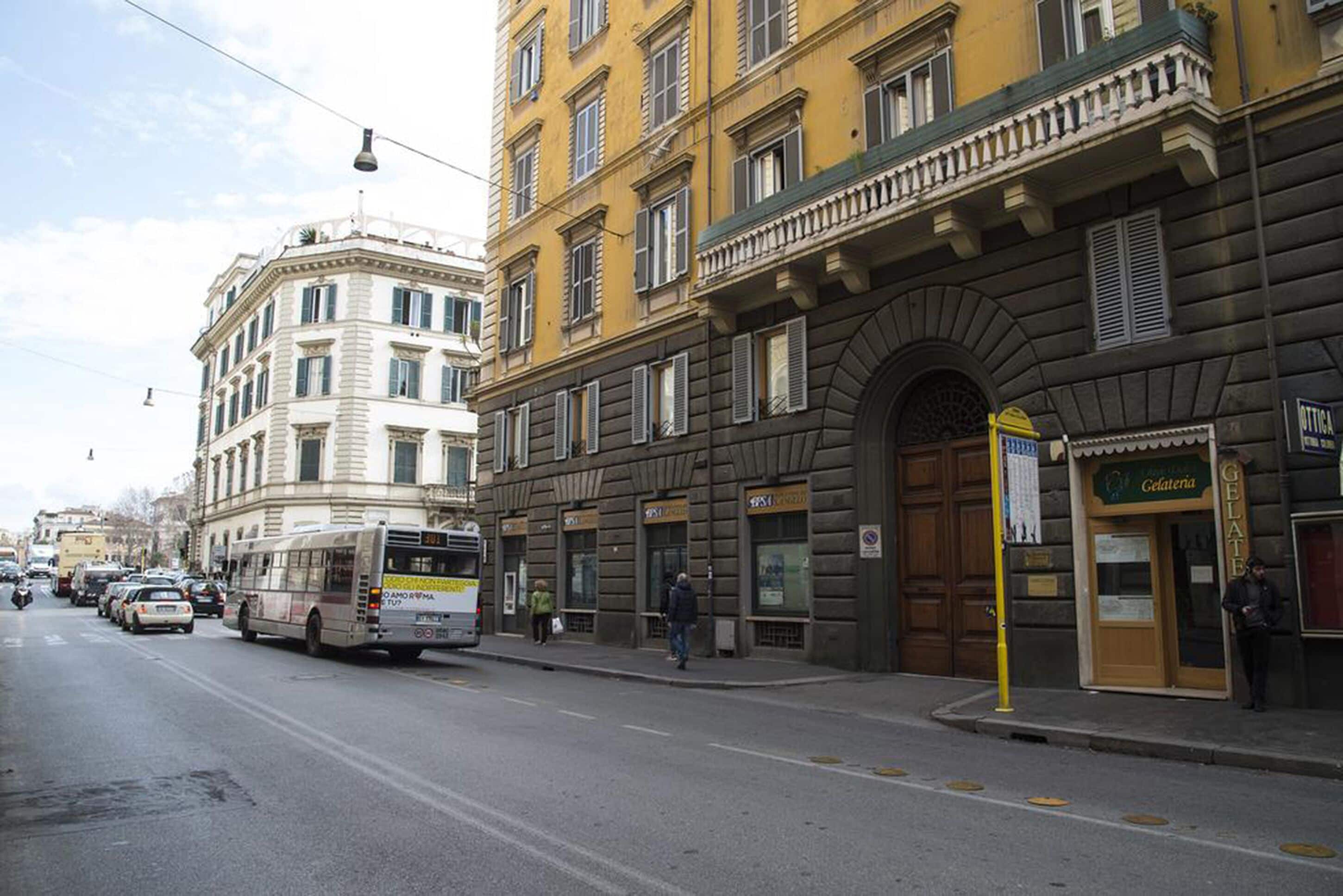 A street with a bus, buildings, and a Gelateria sign.