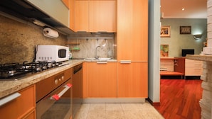 A modern kitchen with wooden cabinets, a built-in microwave, and a gas stove. - Archidee by Ghor (Rome)